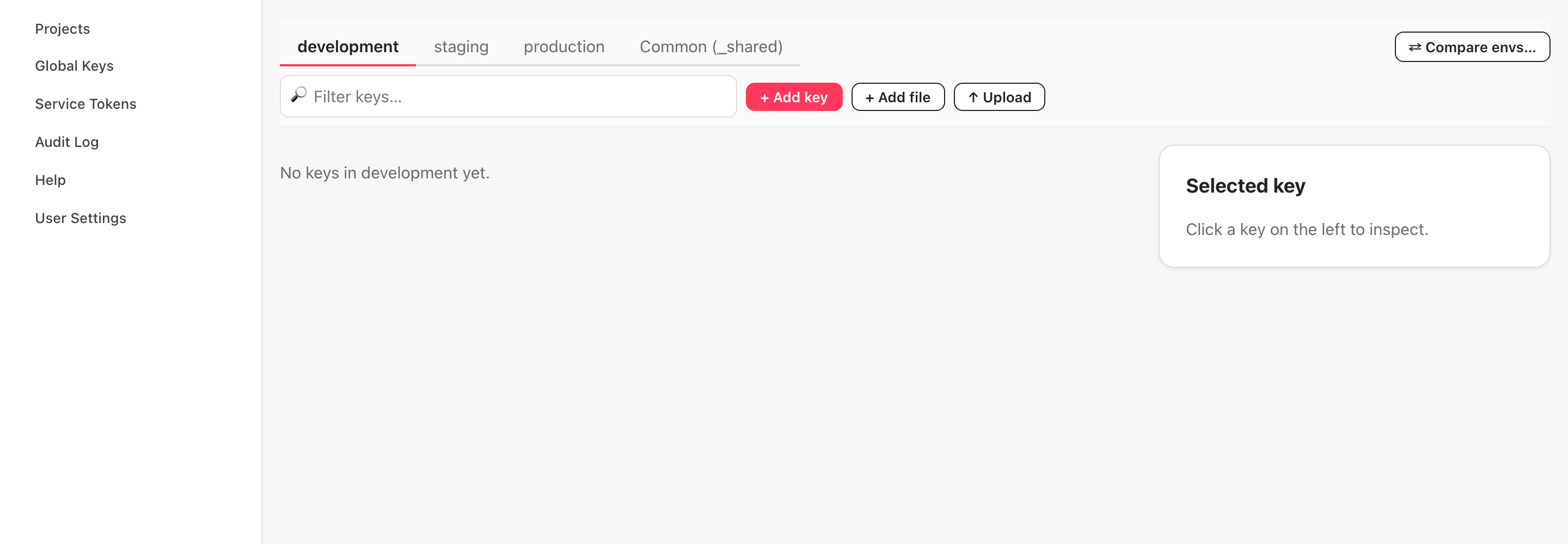 demo-app の Keys タブ（英語 UI・2026 年 10 月 18 日）。環境の切り替え（development・staging・production・Common (_shared)）、Filter keys の検索欄、+ Add key・+ Add file・↑ Upload のボタン。一覧は「No keys in development yet.」の空状態で、右側の Selected key には「Click a key on the left to inspect.」。